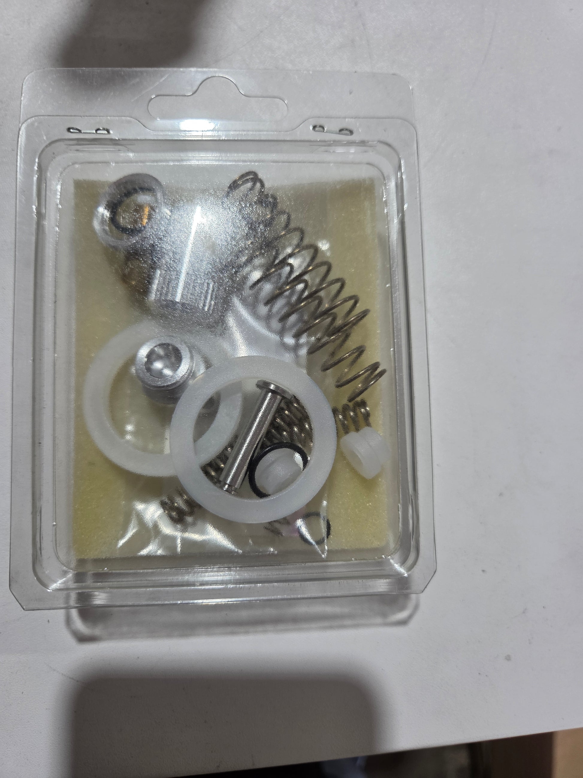 Close-up of mechanical components in a clear plastic packaging on a white background