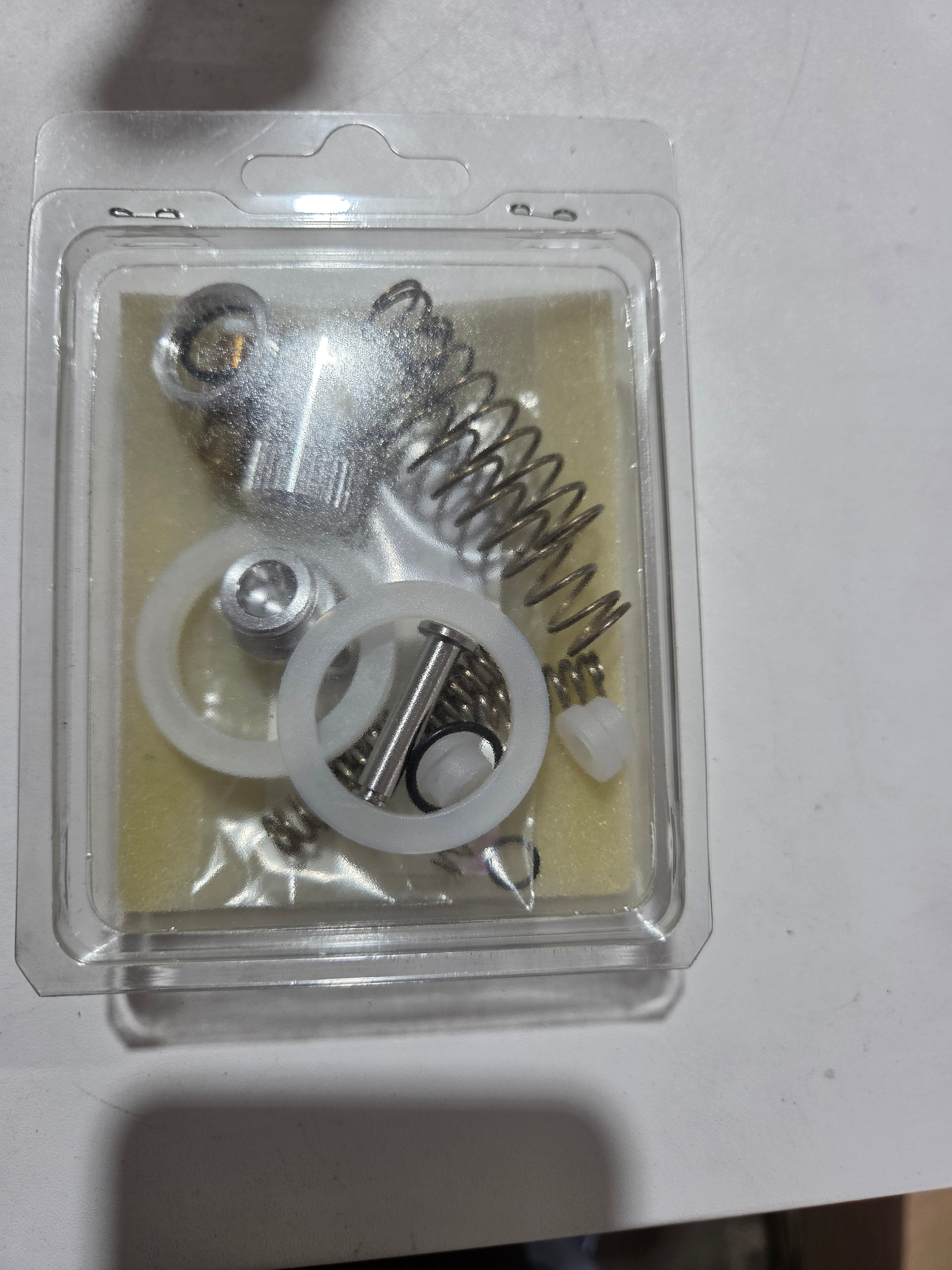 Close-up of mechanical components in a clear plastic packaging on a white background