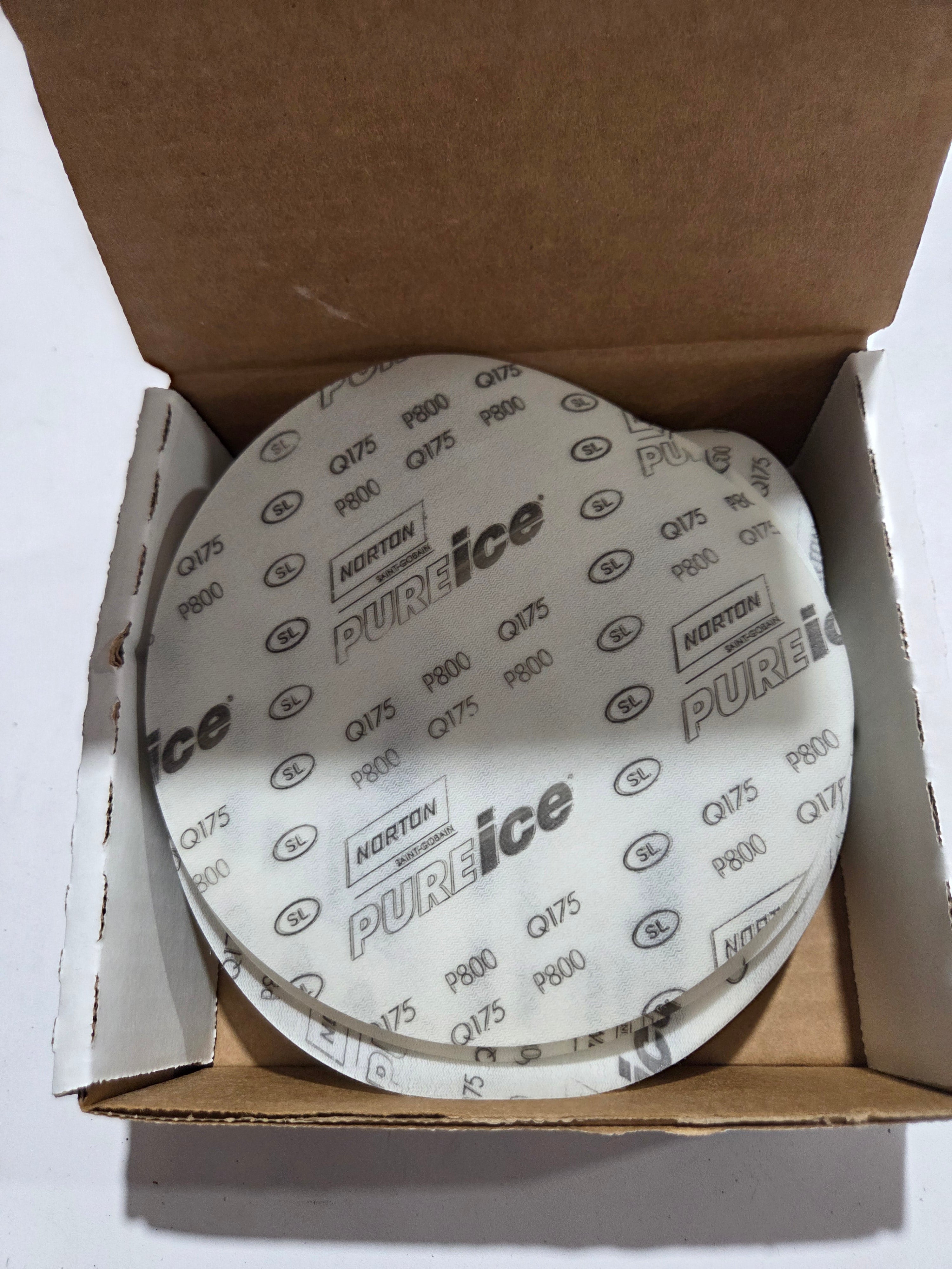 Round white filter with 'PURE ice' branding inside an open cardboard box.