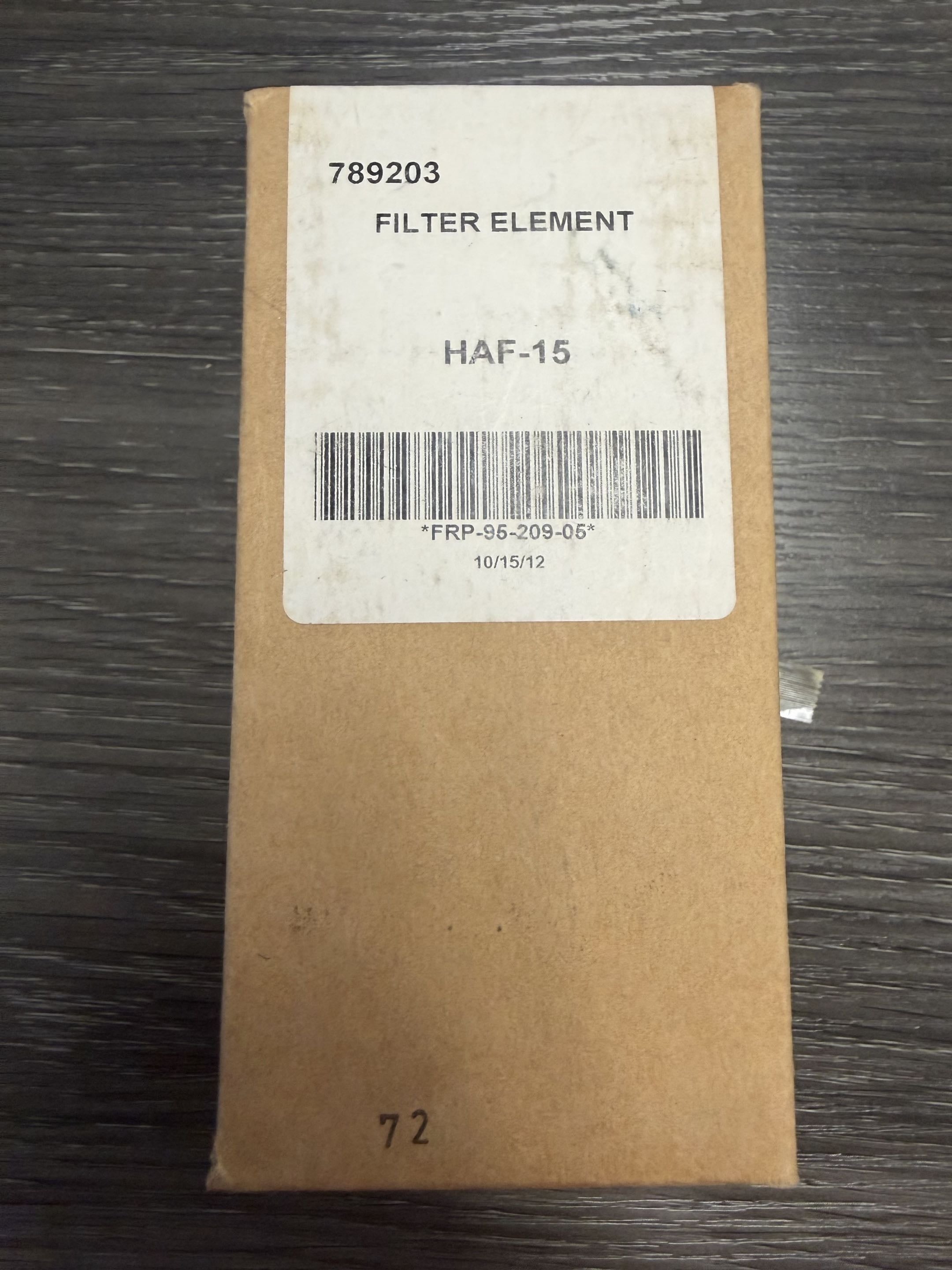 Brown cardboard box with a label on a dark wooden surface