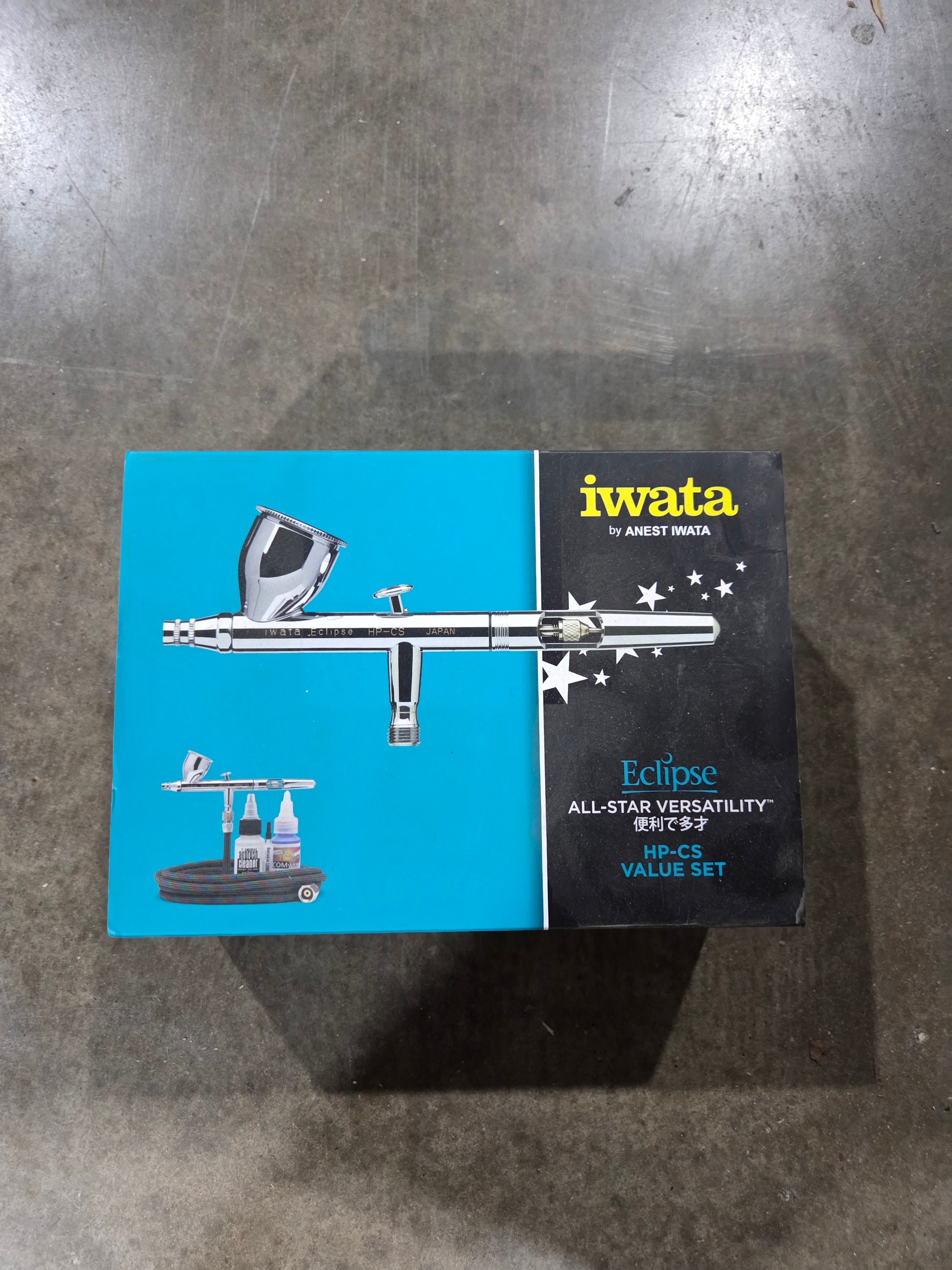 Iwata airbrush packaging on a metallic surface