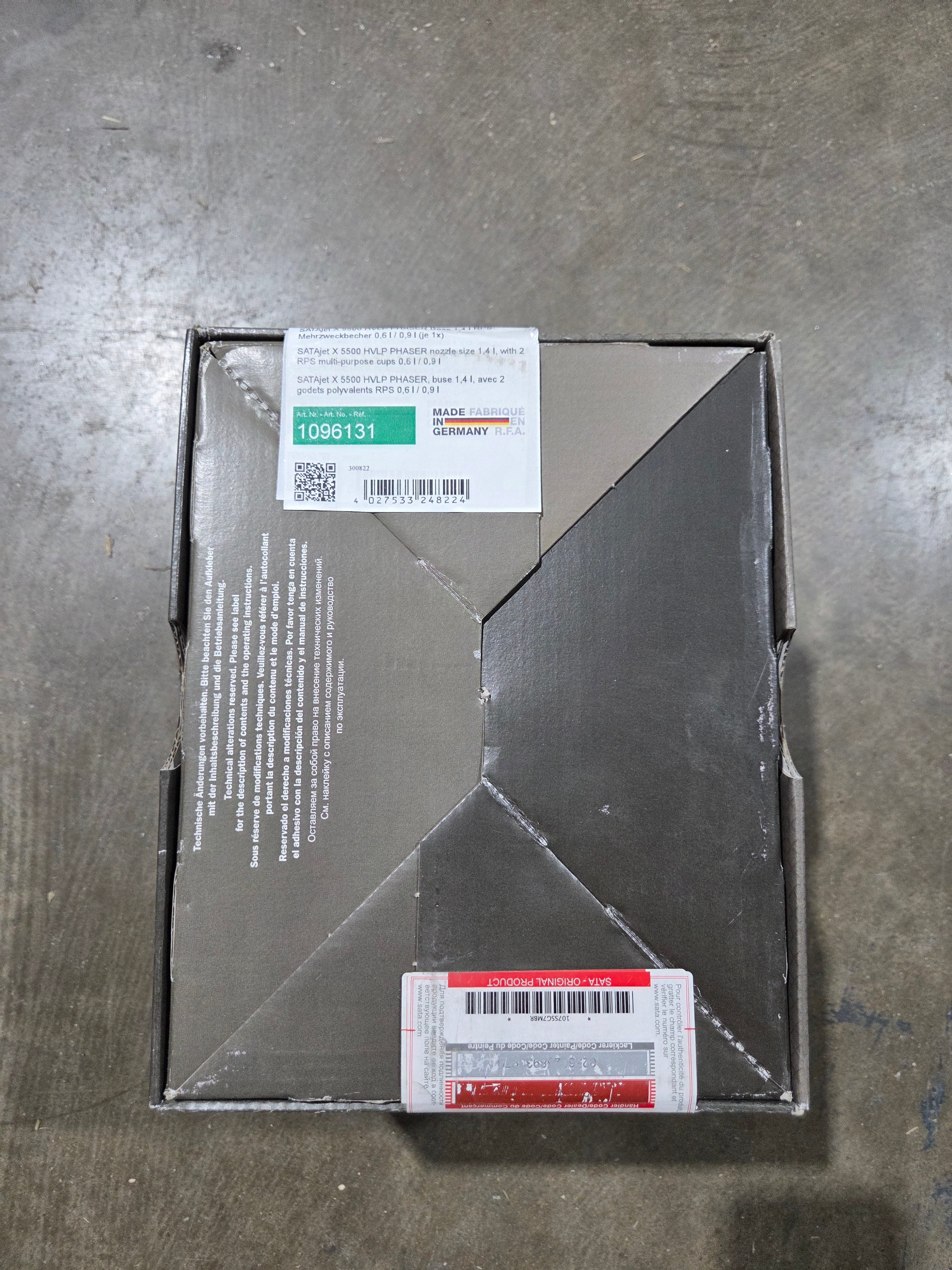 Metal box with labels on a gray surface