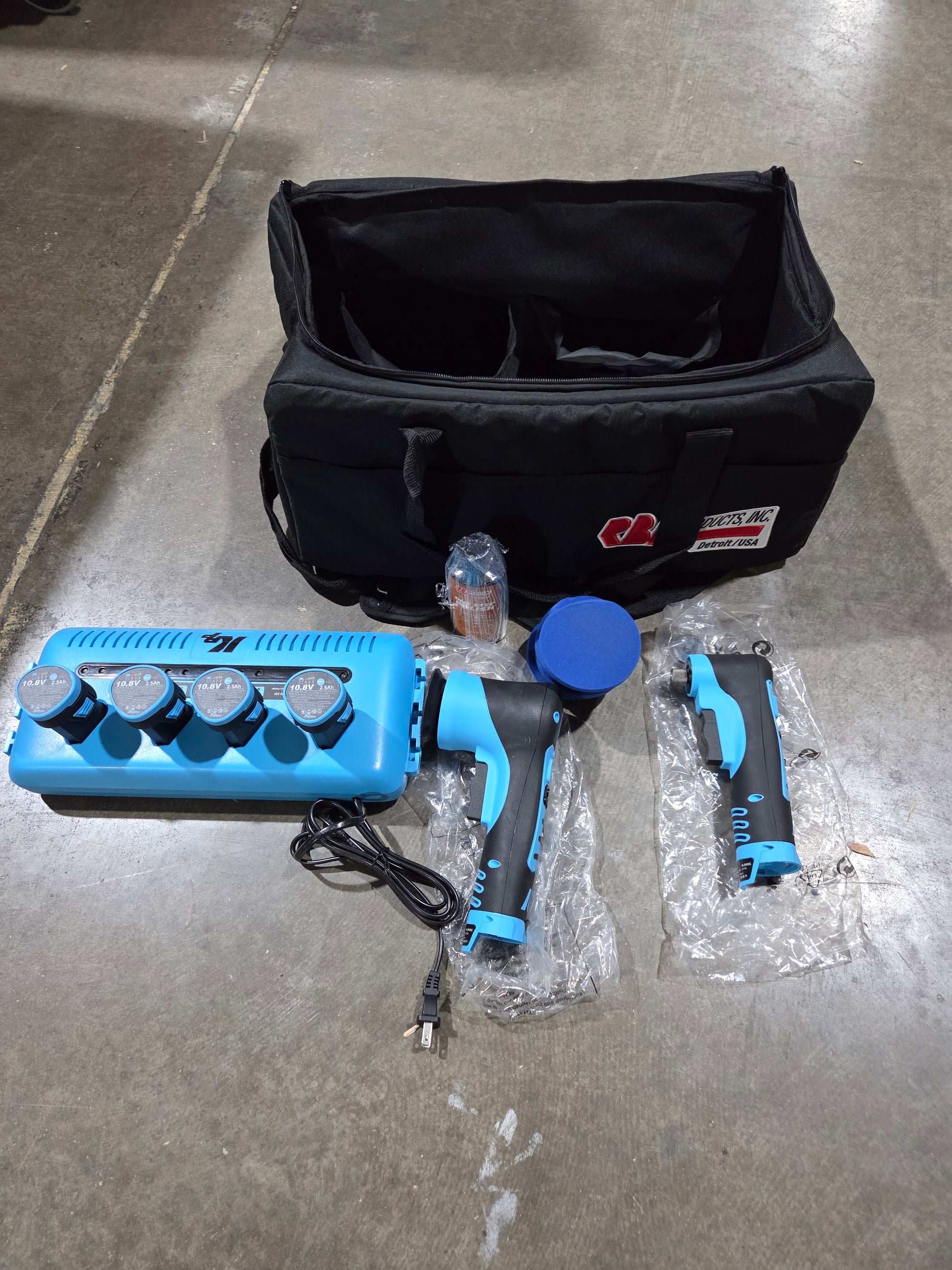 Blue paint sprayer with accessories on a concrete floor