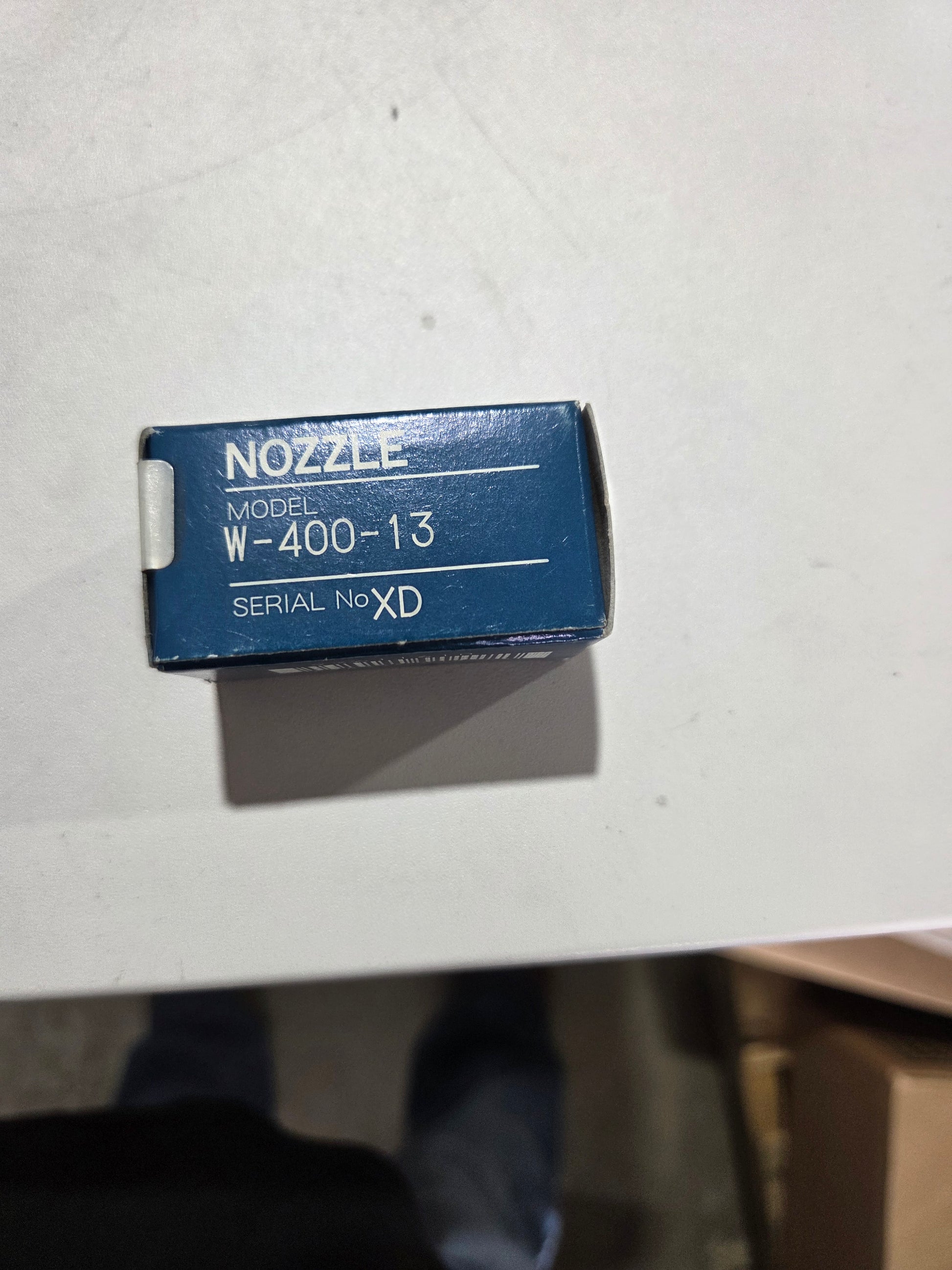 Blue nozzles packaging with text on a white surface