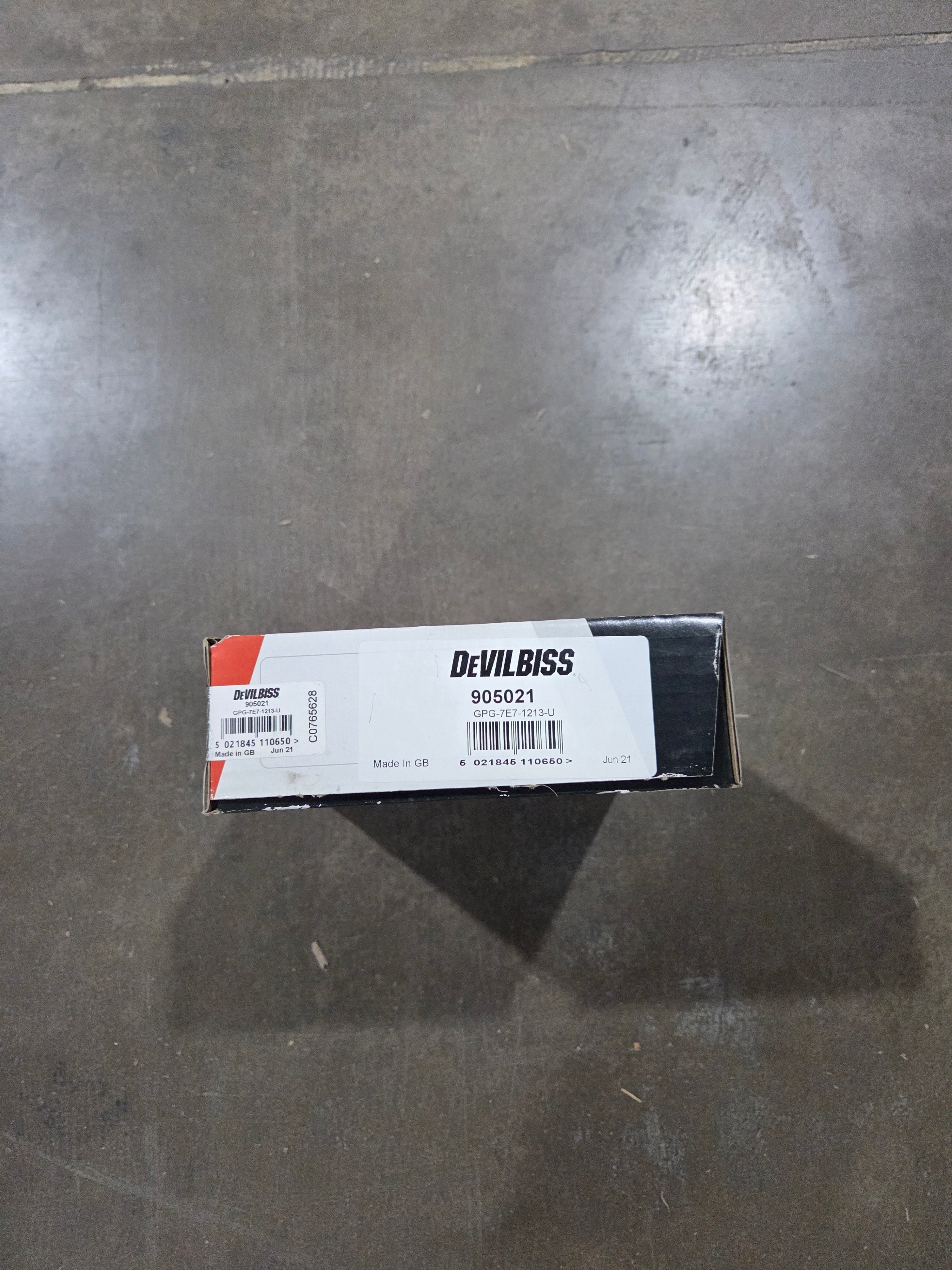 Small box with a label on a gray concrete floor