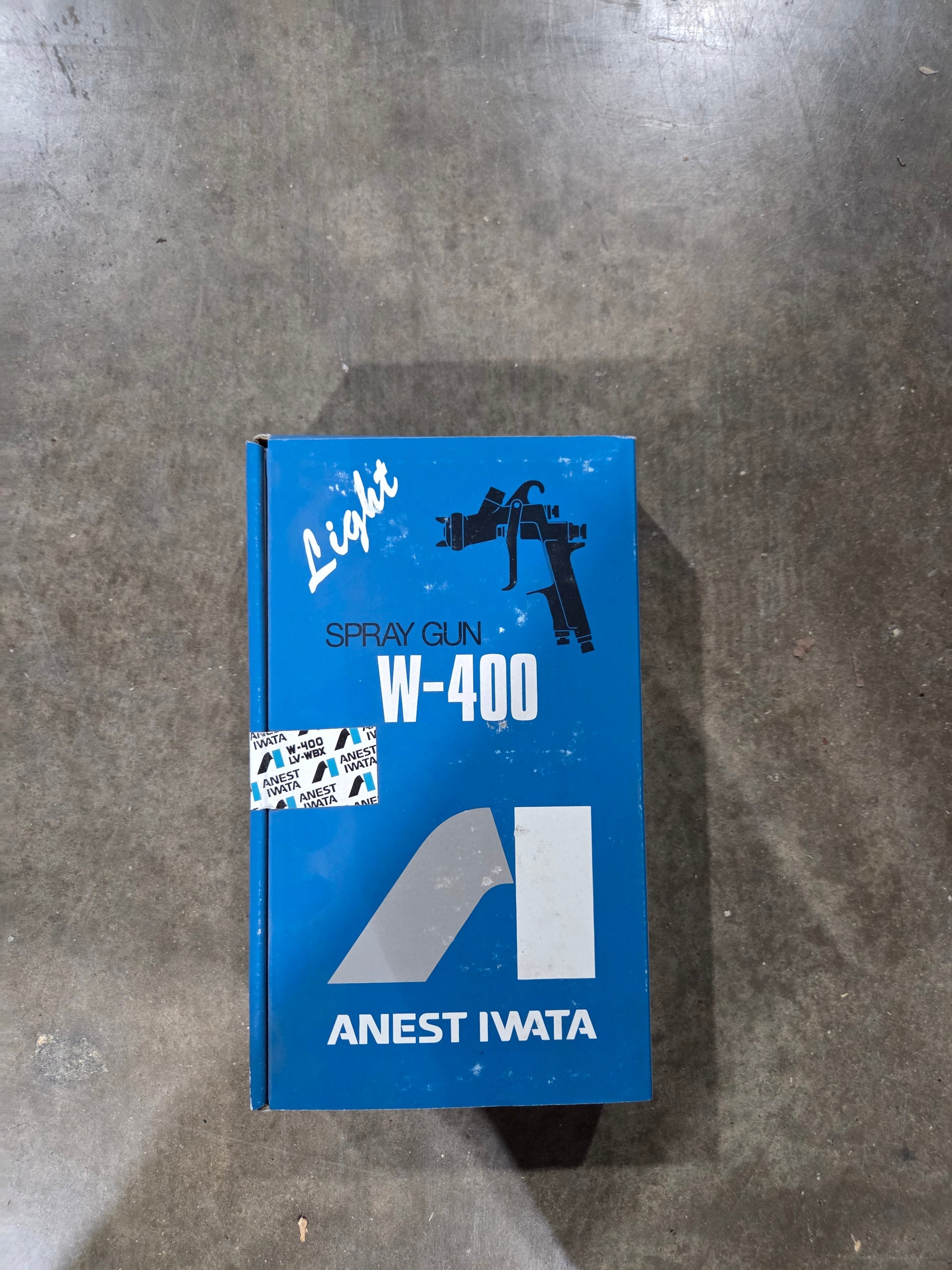 Blue box with 'Anest Iwata' branding on a gray surface