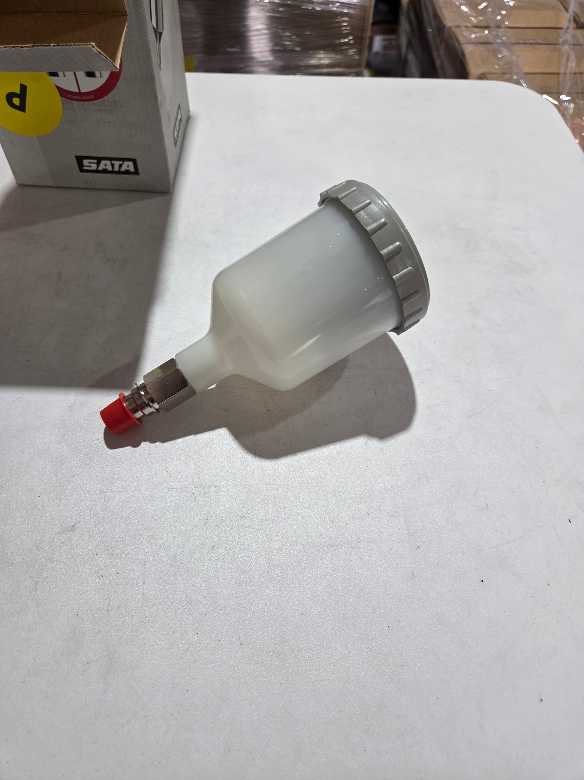 White spray gun with red nozzle on a white background