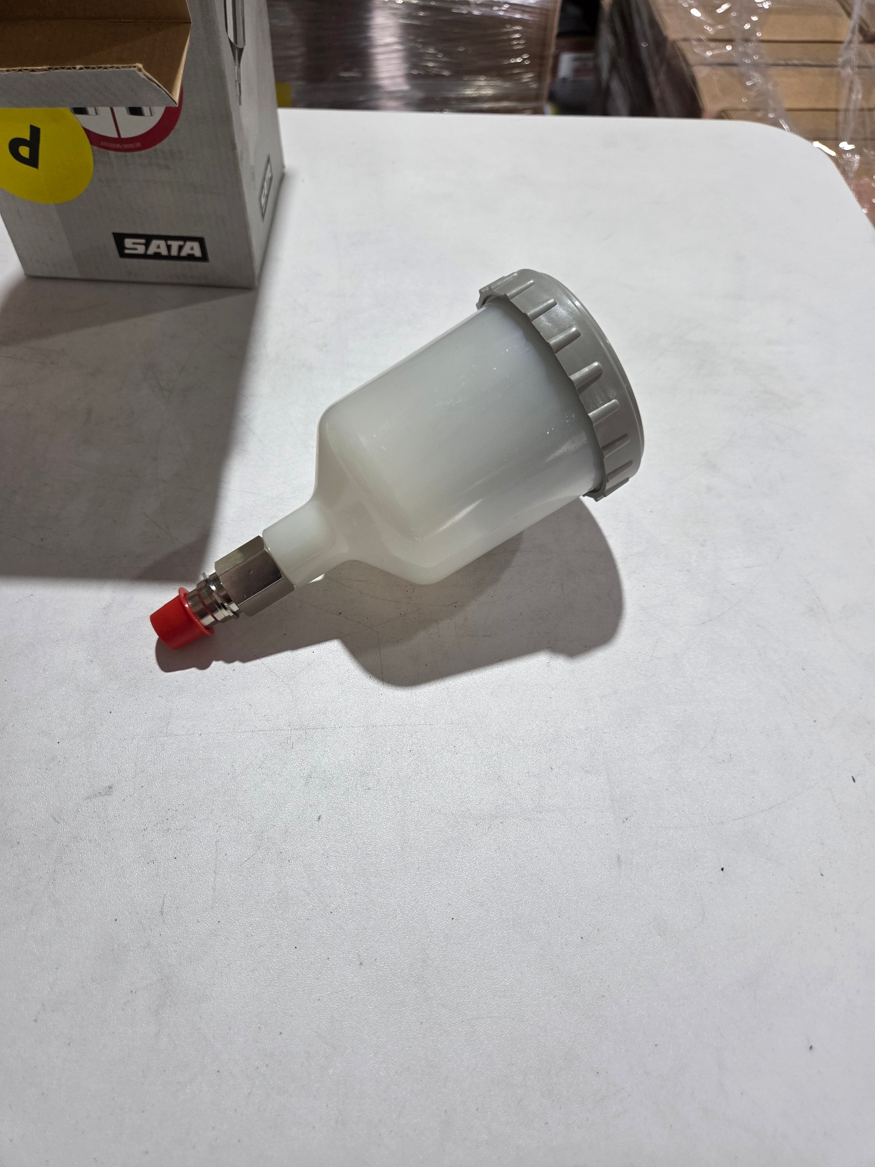 White spray gun with red nozzle on a white background