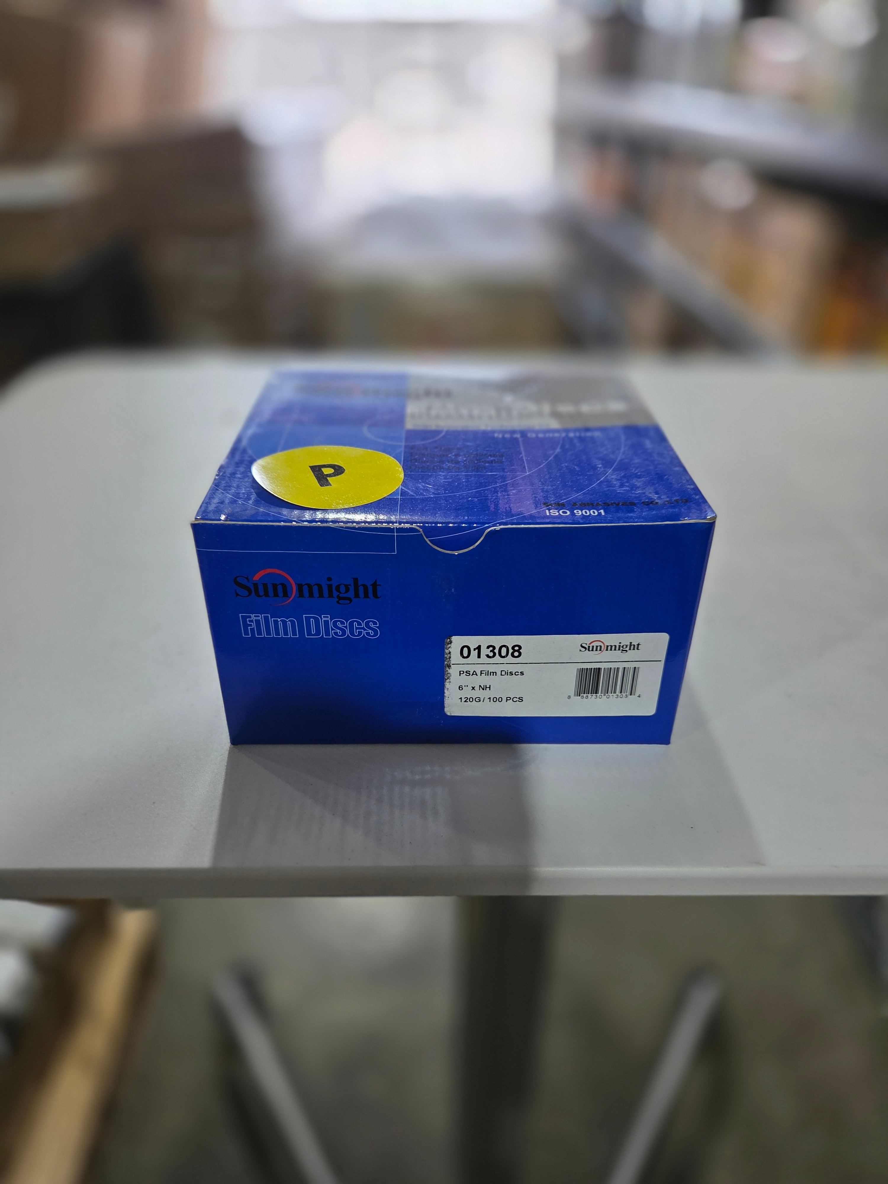 Blue box with a yellow label on a white surface