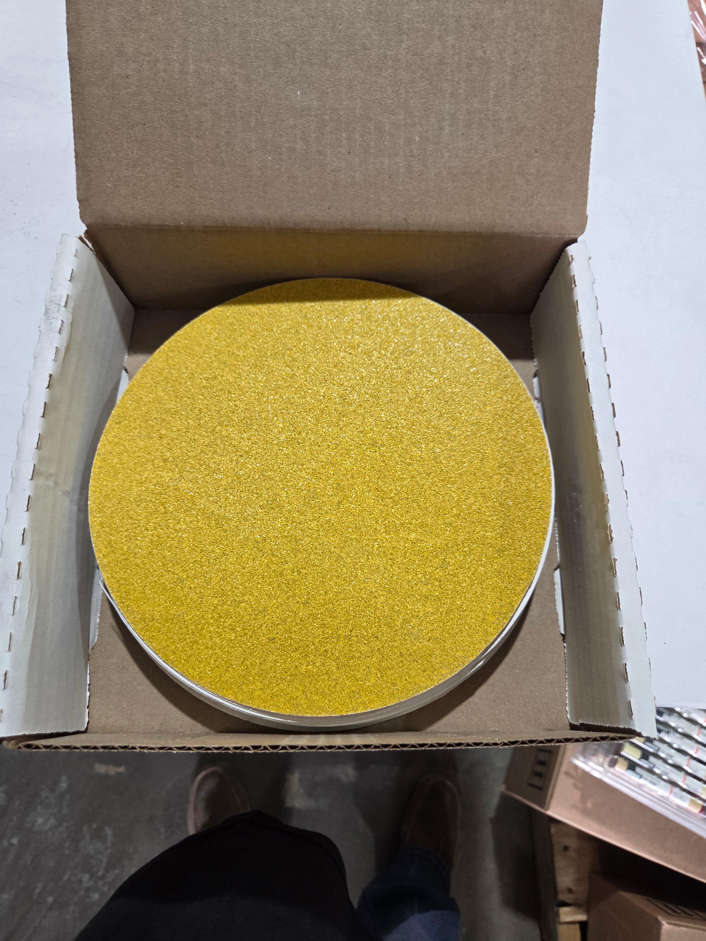 Yellow circular object in an open cardboard box