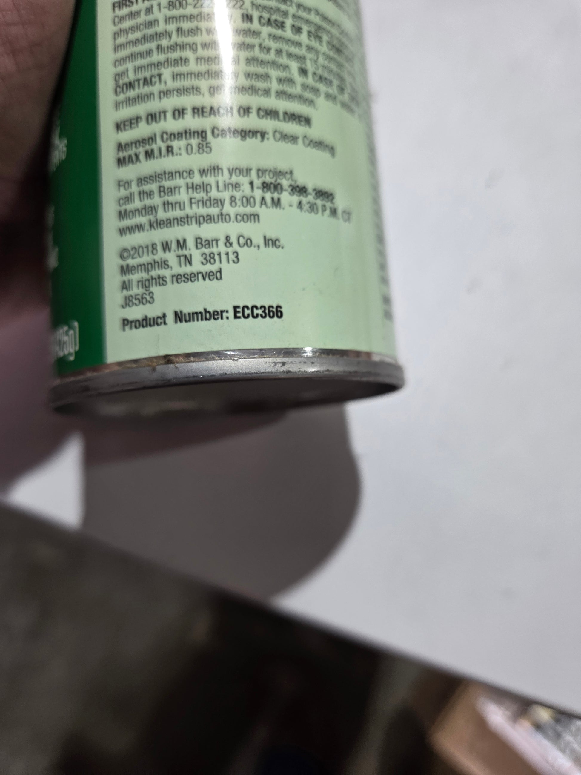 Close-up of a can with text on a white surface