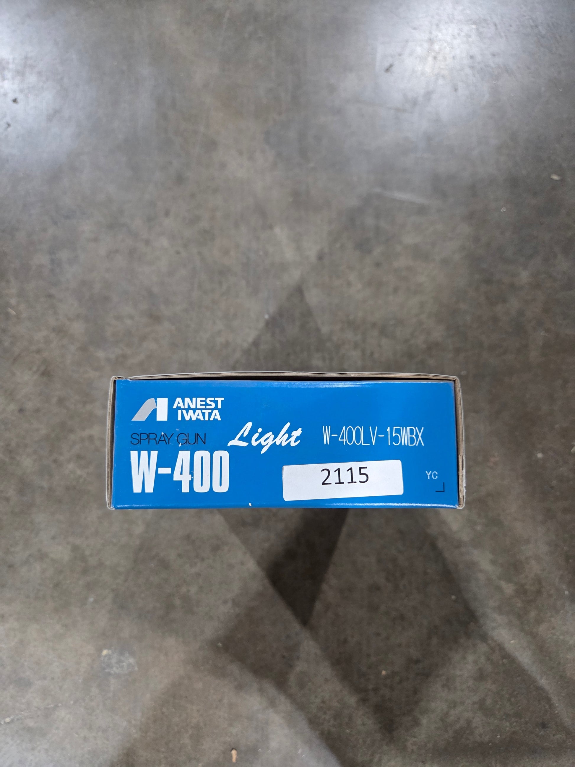 Blue box with white label on a gray concrete floor