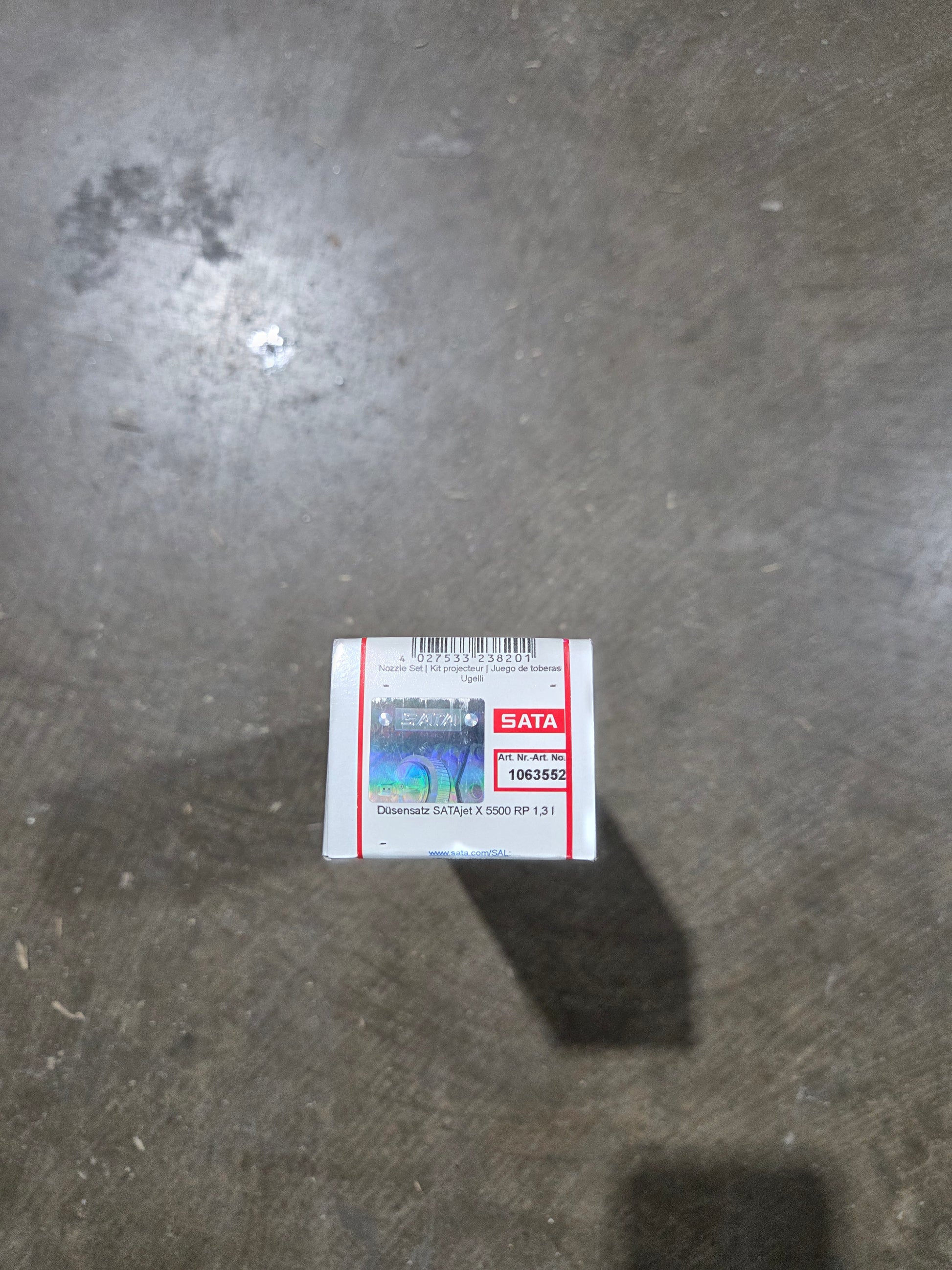 Small box with a label on a gray concrete surface