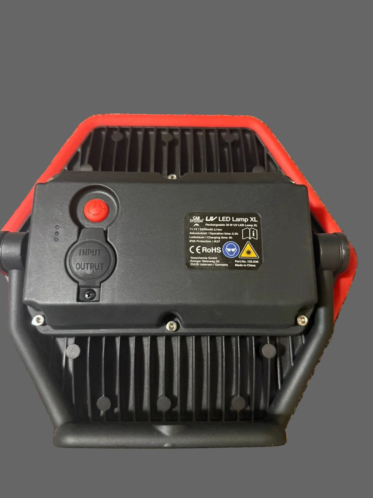 Small electronic device with a red light on a dark surface